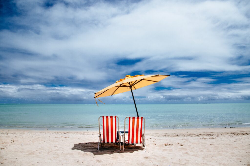 plage avec 2 parasols symbolisant l'été, moment propice à la réflexion